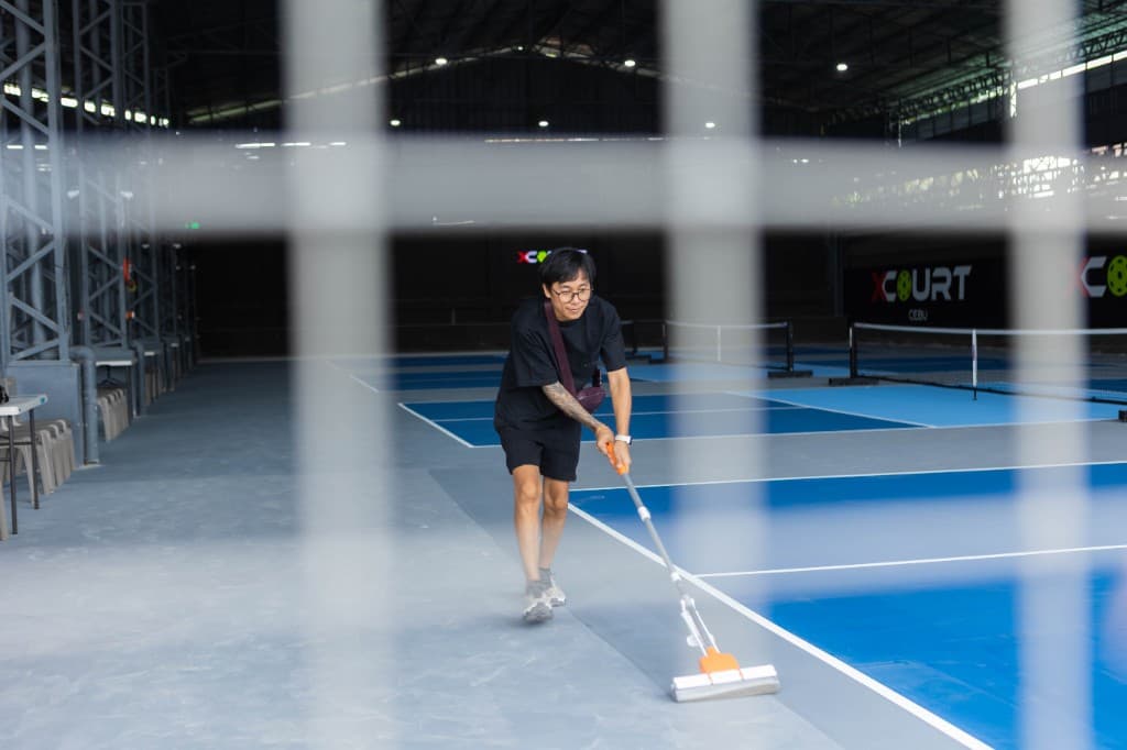 Staff cleaning an X Court Cebu pickleball court